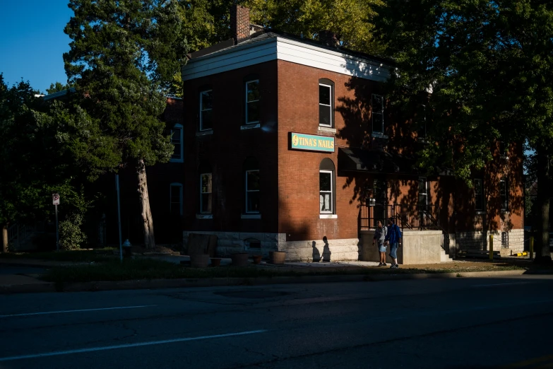 a couple of men standing outside of a building next to trees