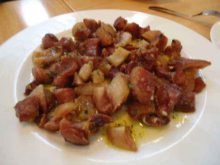 a white plate topped with bacon, olives and other toppings