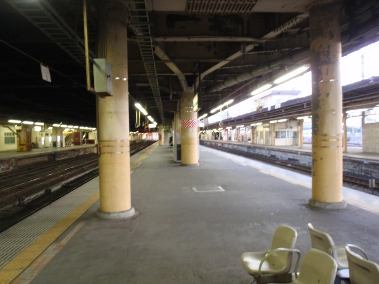 there are four yellow chairs sitting by a train