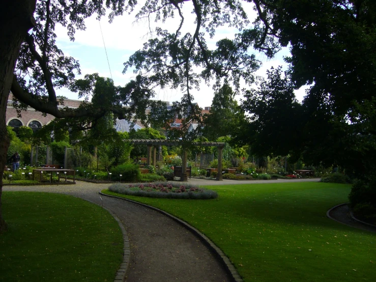 a path that has flowers in the middle with trees