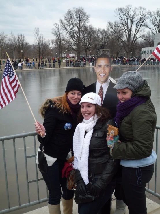 two women and a girl stand with an american flag