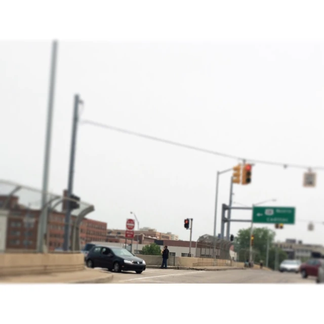 a car driving down the street with a person at an intersection