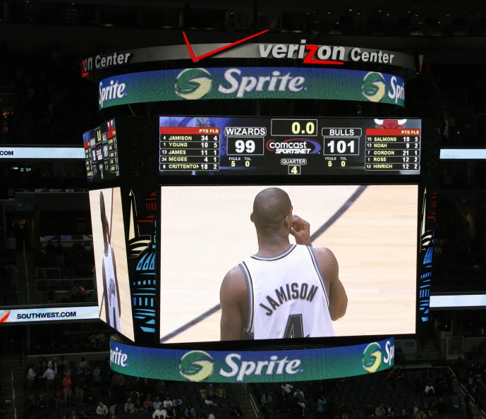 a man on a cell phone on top of a basketball court