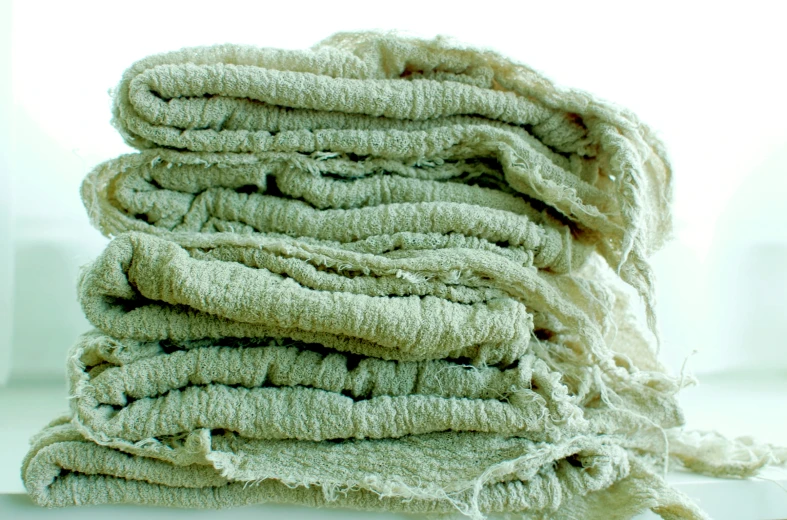 a pile of linens are stacked on top of each other
