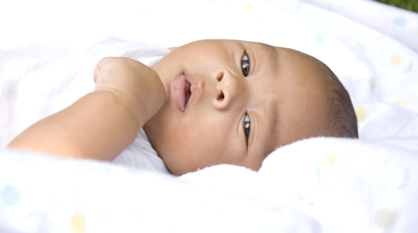 an adorable baby is lying on the bed