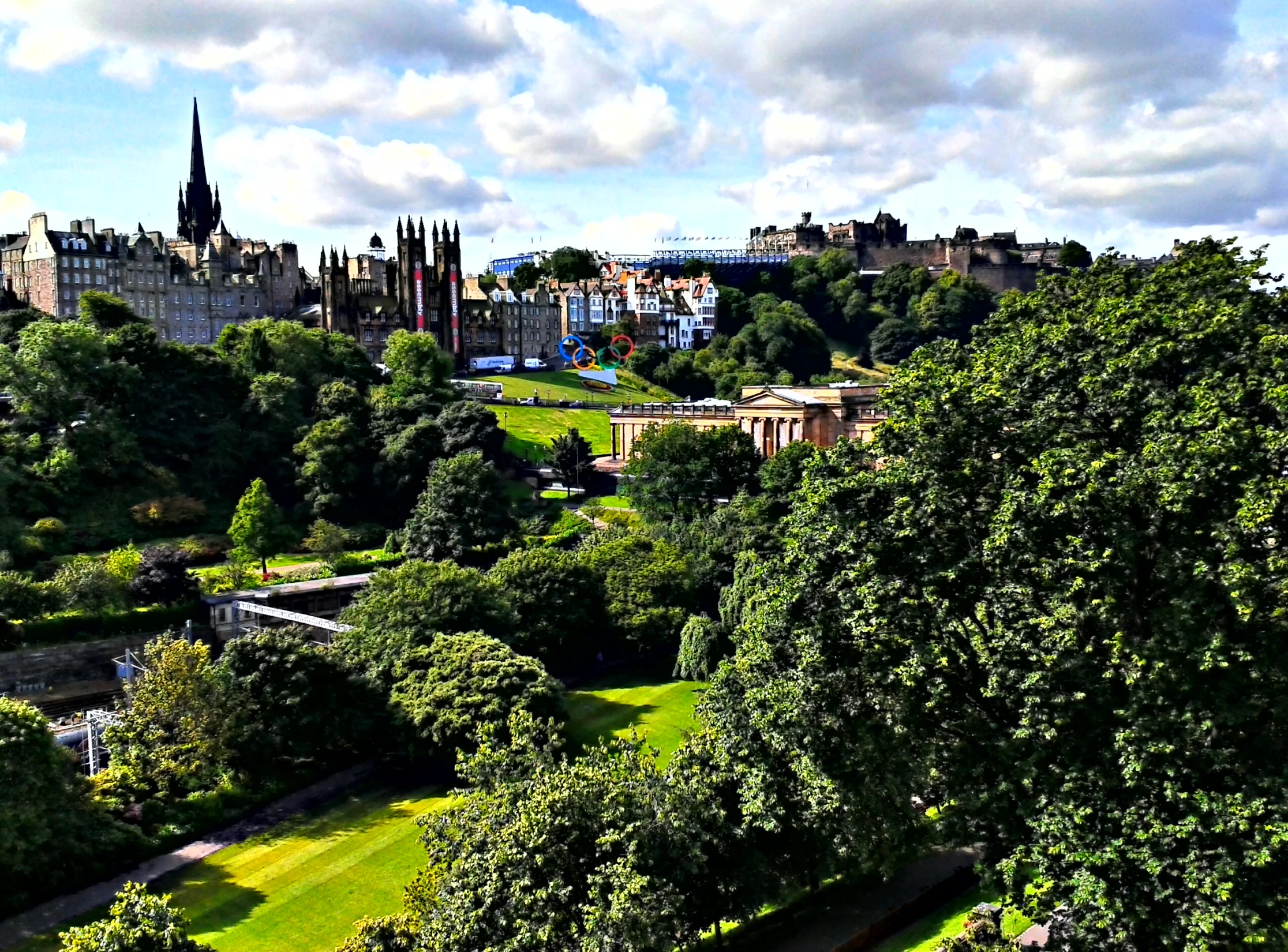 a scenic view of a city with trees and lawn