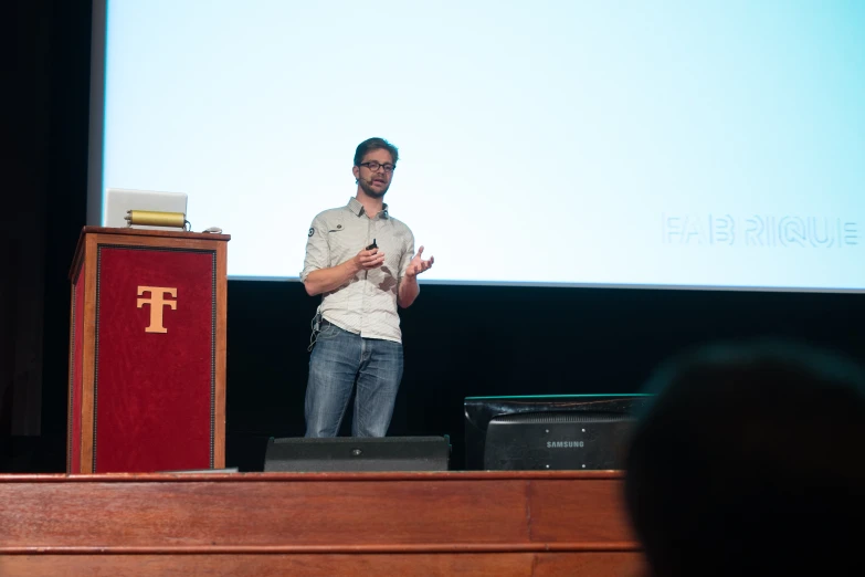 a man standing at a podium, giving a presentation