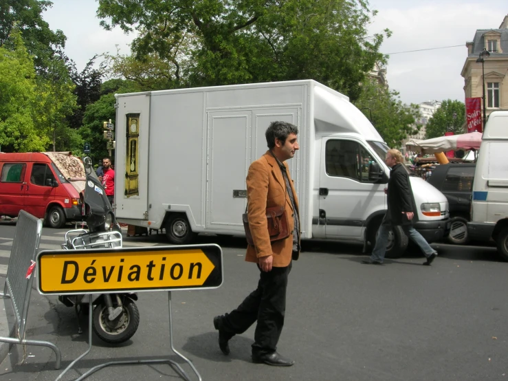 the man is walking past a sign saying devitation