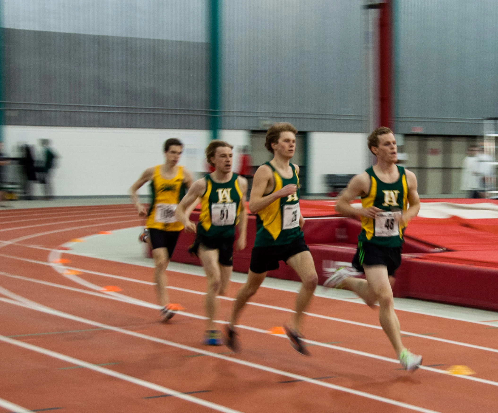 four men run a race on the track