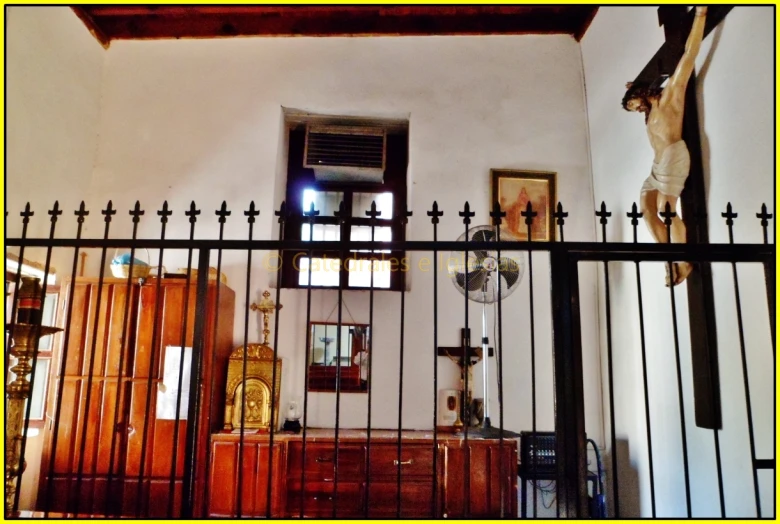 a cross hangs on the wall near a dresser