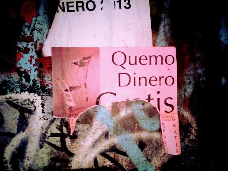 a pink sign hanging from the side of a building