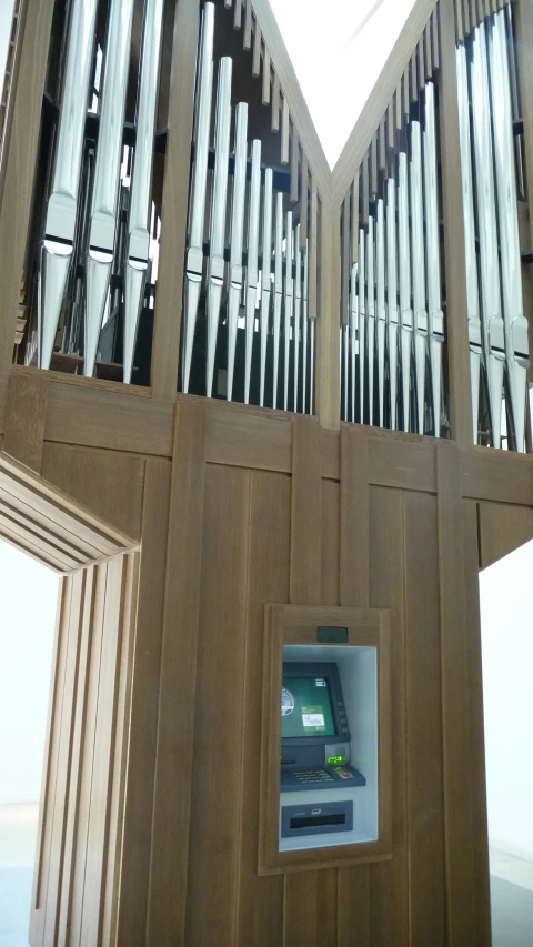 an organ sitting behind some windows with a sky background