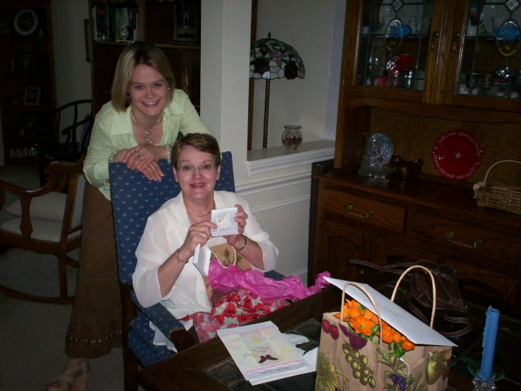 two women pose for a pograph in a living room