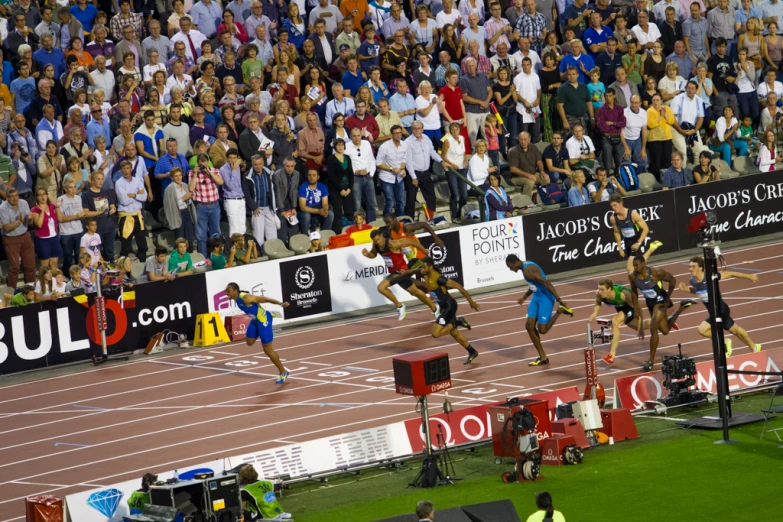 a group of men running down a track next to each other