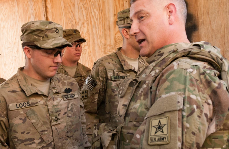 a group of soldiers that are talking and looking at soing