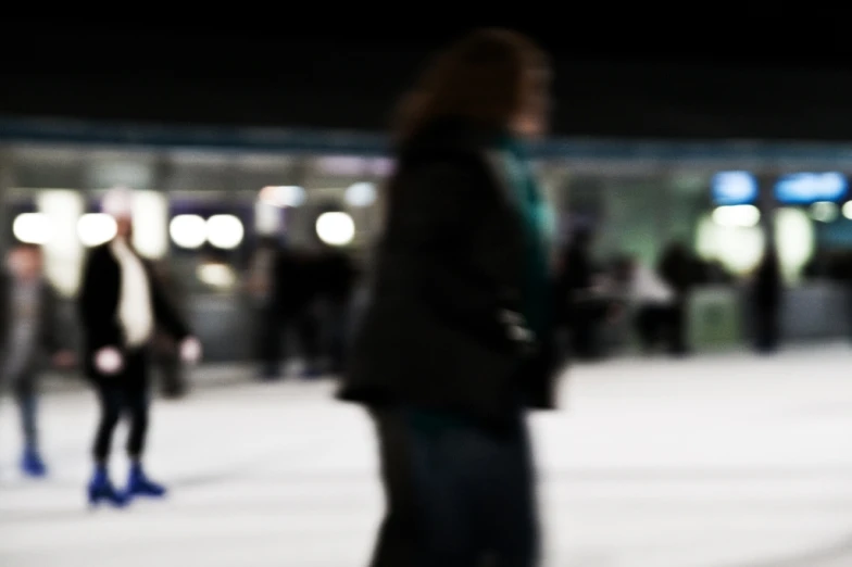 blurry image of people skating around an indoor rink