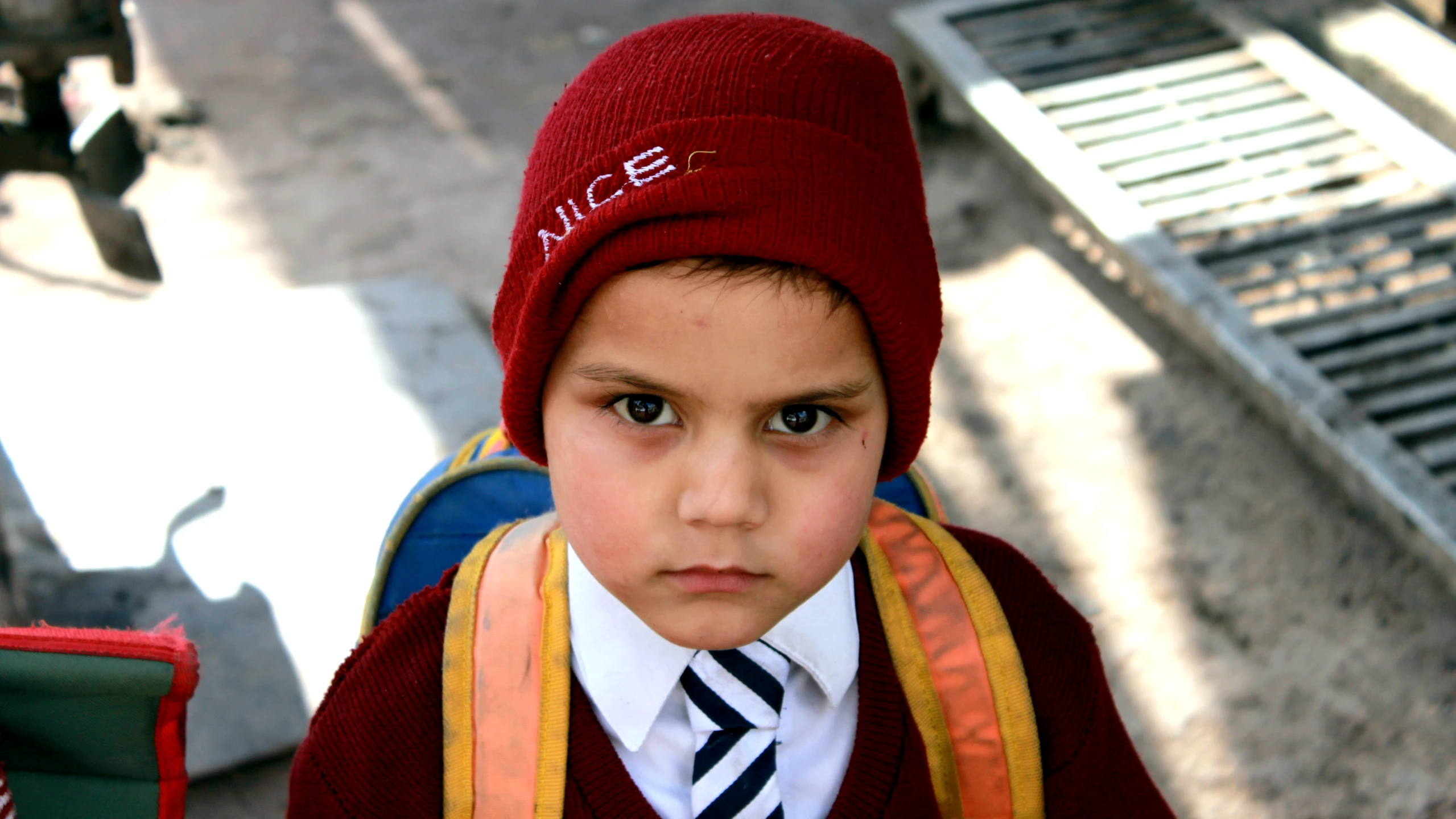 a  in a suit and tie wearing a red beanie