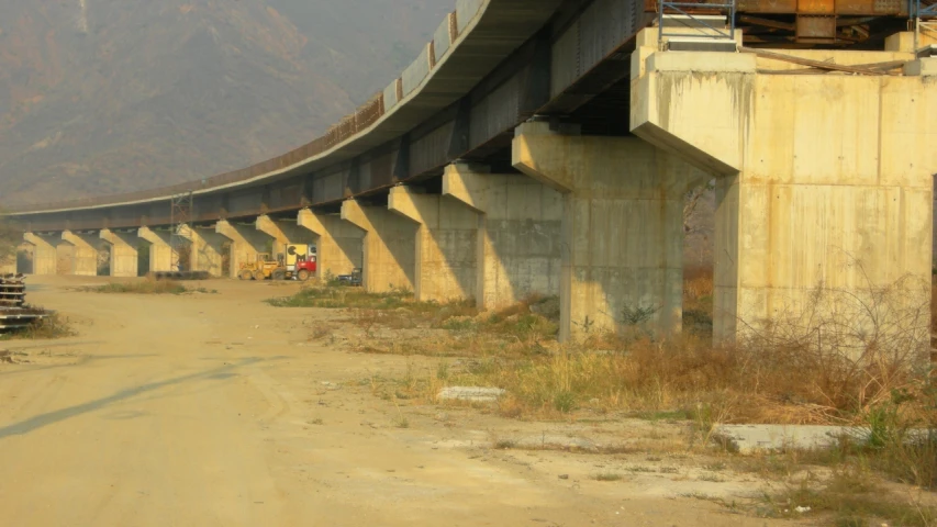 an old dirt road that has a train bridge on it