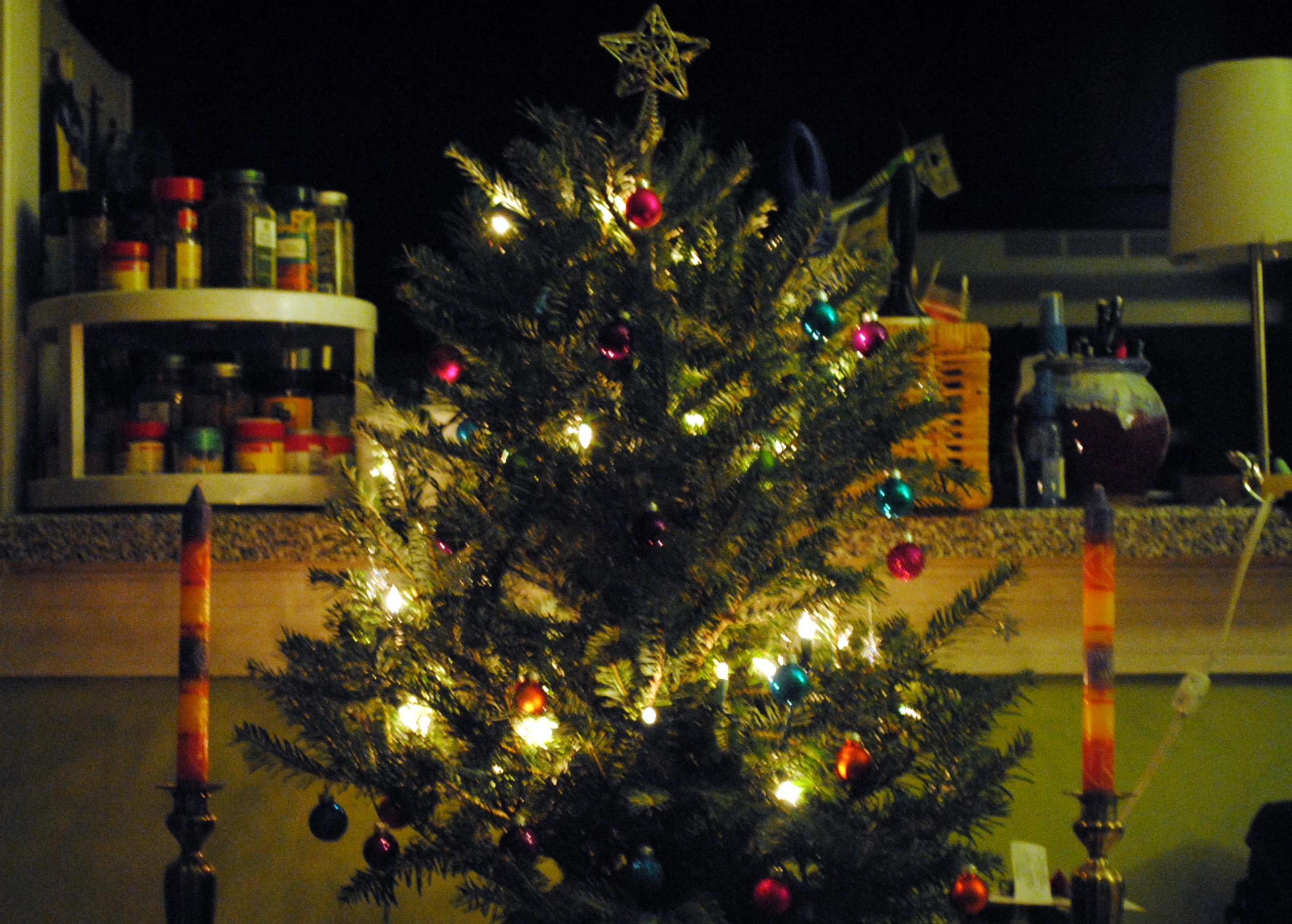 a lit christmas tree with various ornaments on it