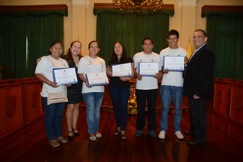 a group of people holding paper with one person standing behind them