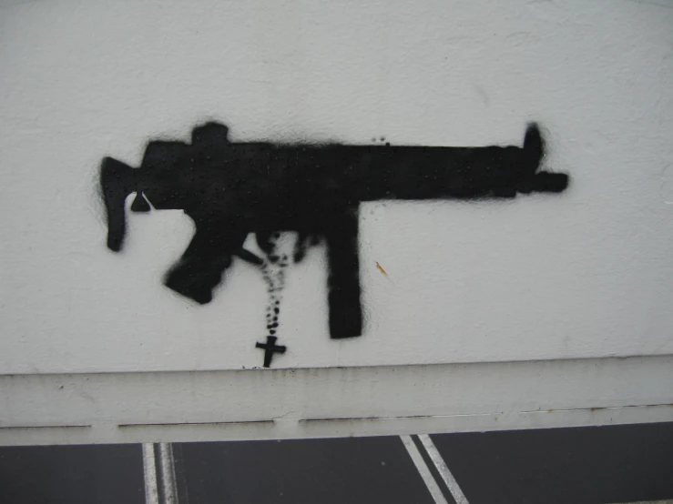 graffiti on a building that shows a gun that is decorated in cross - stitch