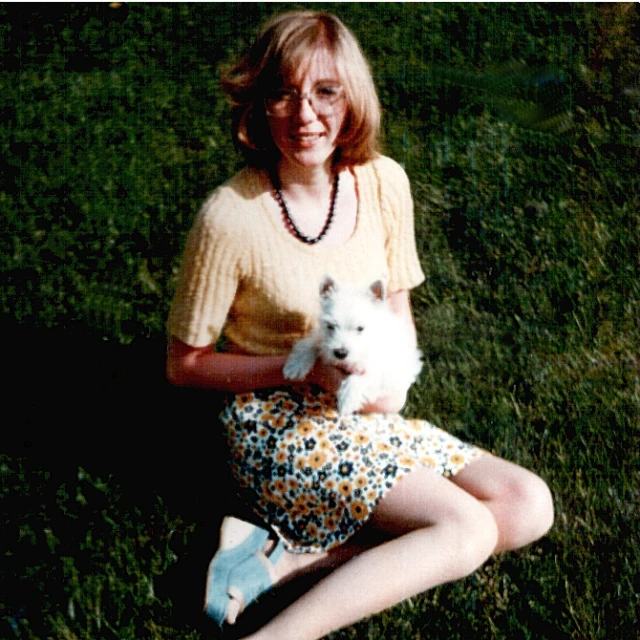 a lady with a small white dog in her lap