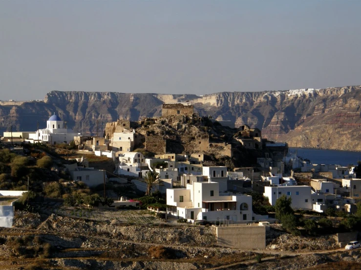 small village in middle of rocky terrain with mountain backdrop