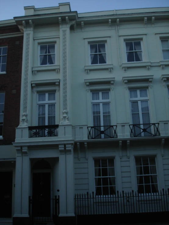 the front of a building with several balconies on the windows