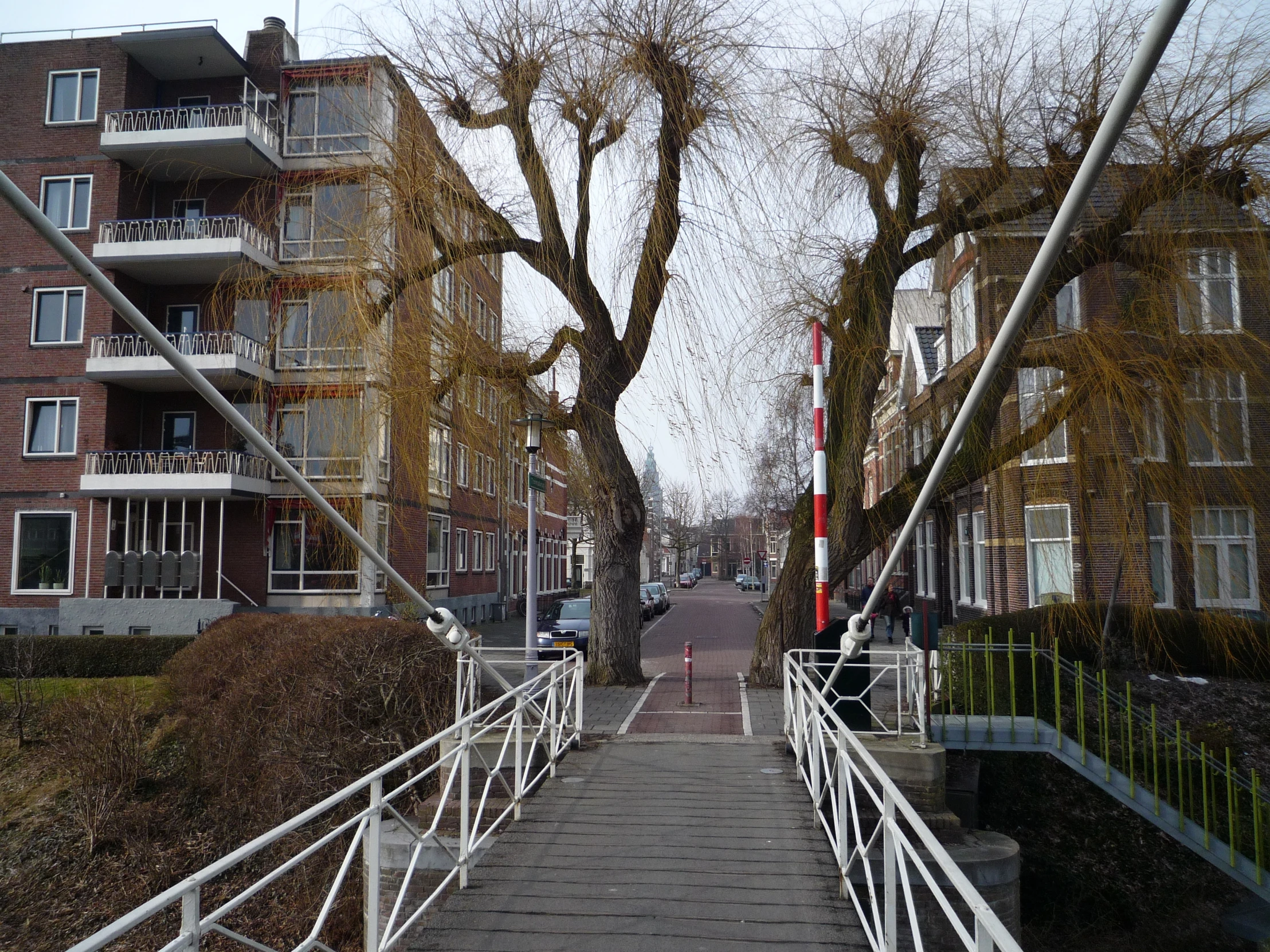 a small bridge going up a steep hill to a tall building