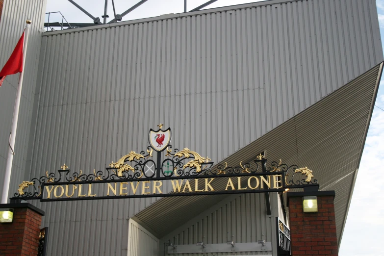 a black and gold sign saying i would never walk alone