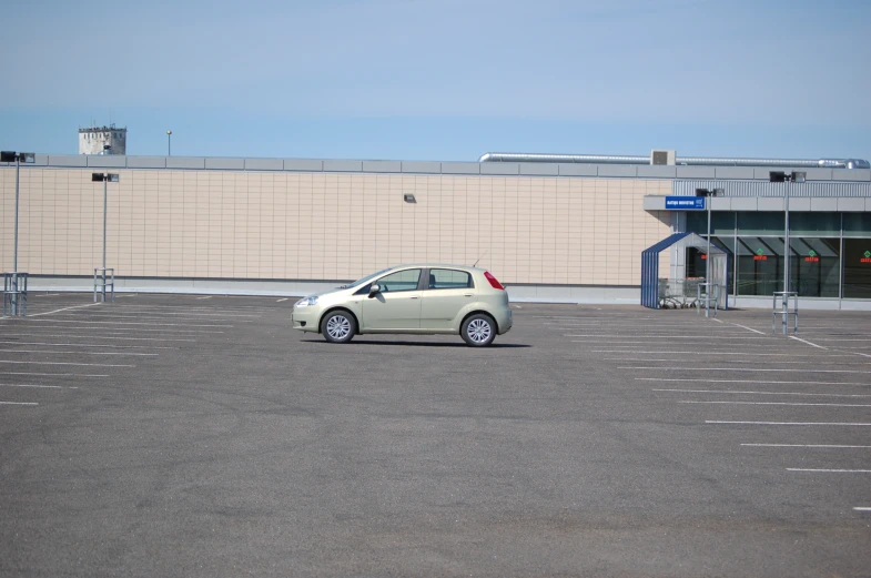 the white car is parked in the parking lot of the airport