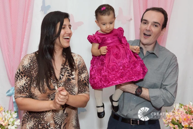 a young woman holding a small child with an older man