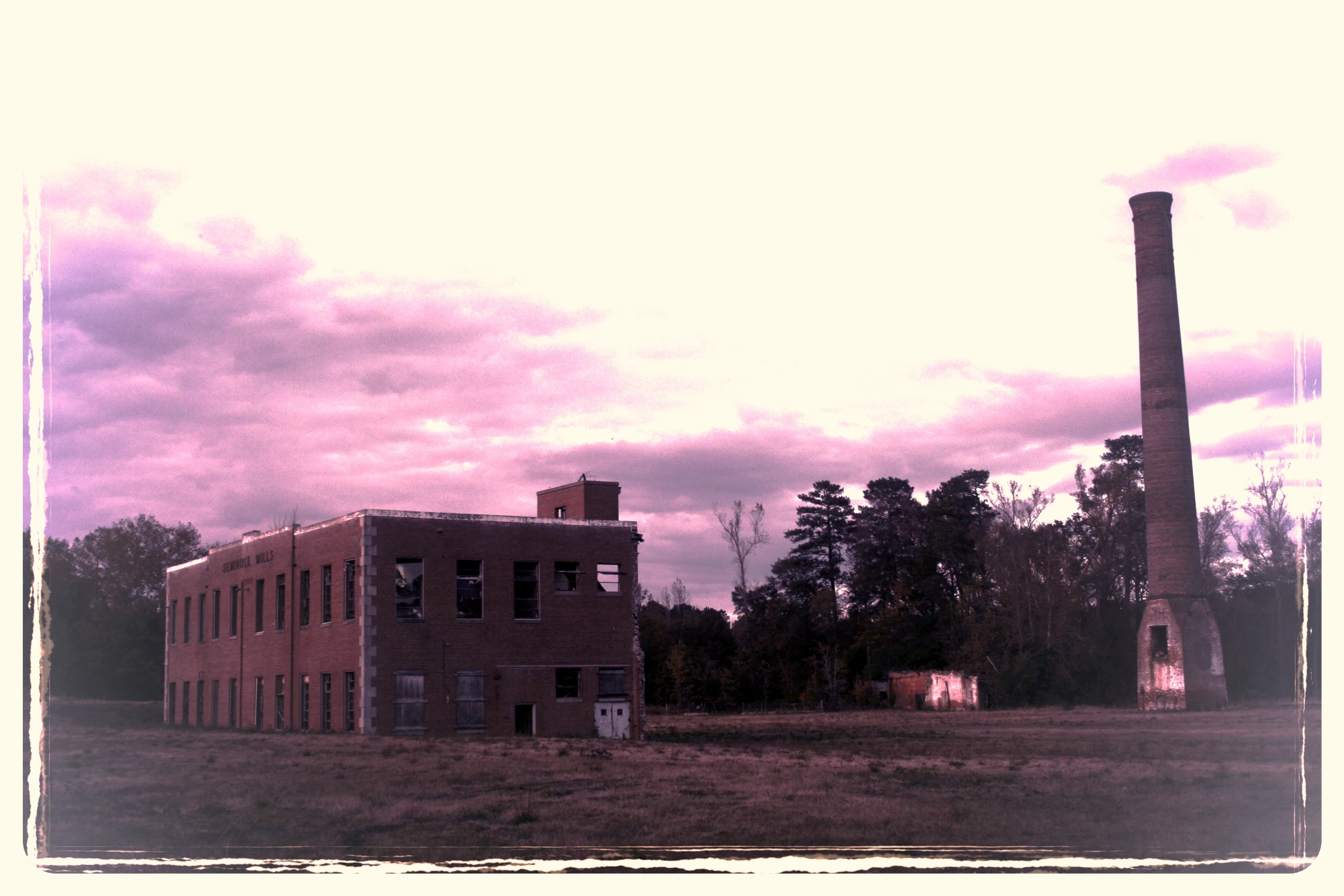 an old factory building in the middle of the countryside