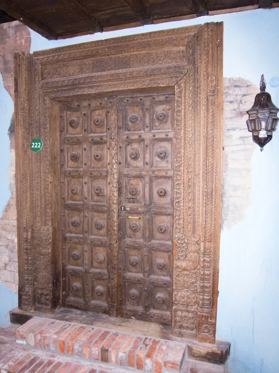 a large, carved door in front of a blue wall