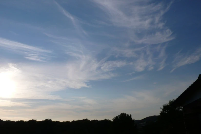 a sky full of cloud over a field with houses