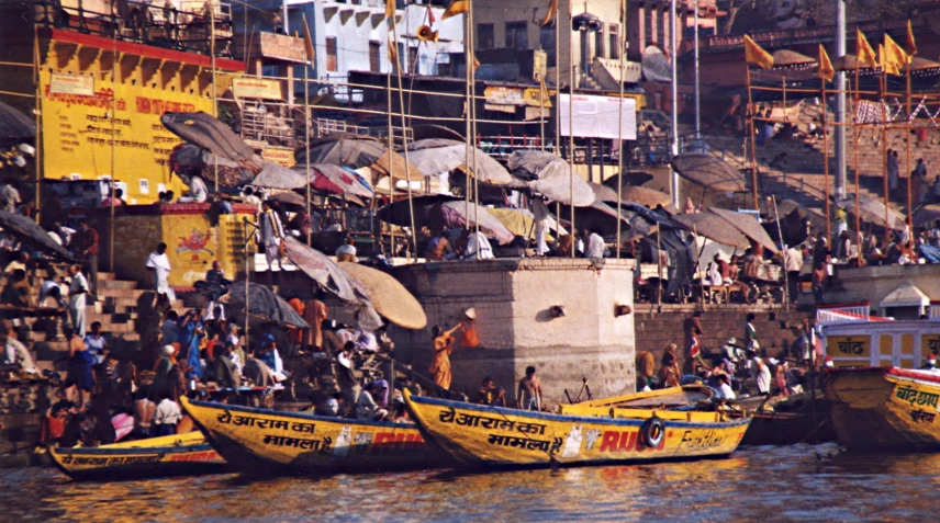 a river scene with many boats and lots of people hanging out