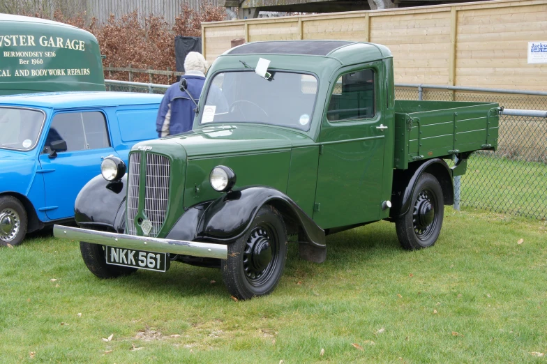 a classic pickup truck parked beside a blue van