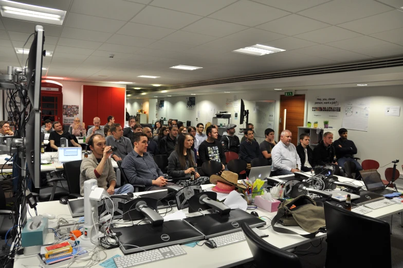 people gathered in a room looking at laptop computers