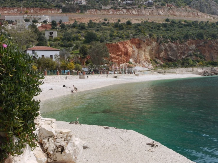 people are on the beach near water and mountains