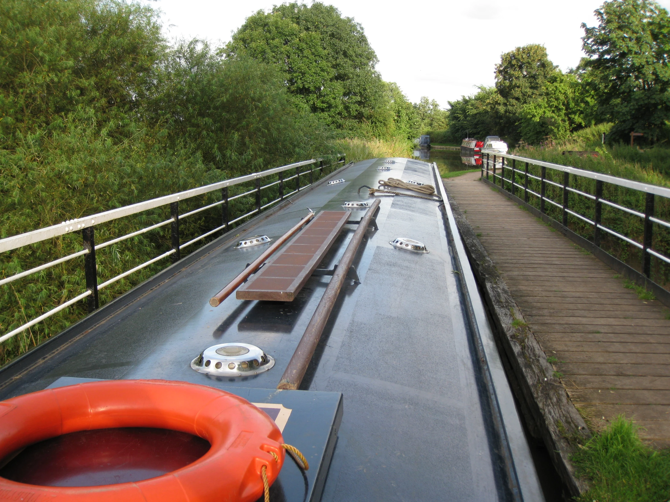 a boat traveling down a canal with trees in the background