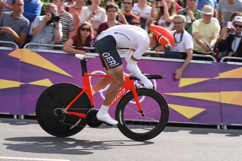 a man riding on top of a bike in front of a crowd