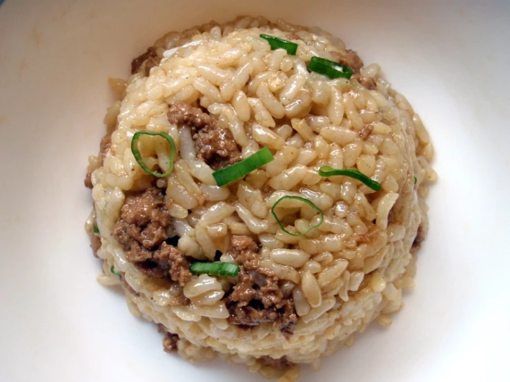 a plate topped with rice and meat next to another plate