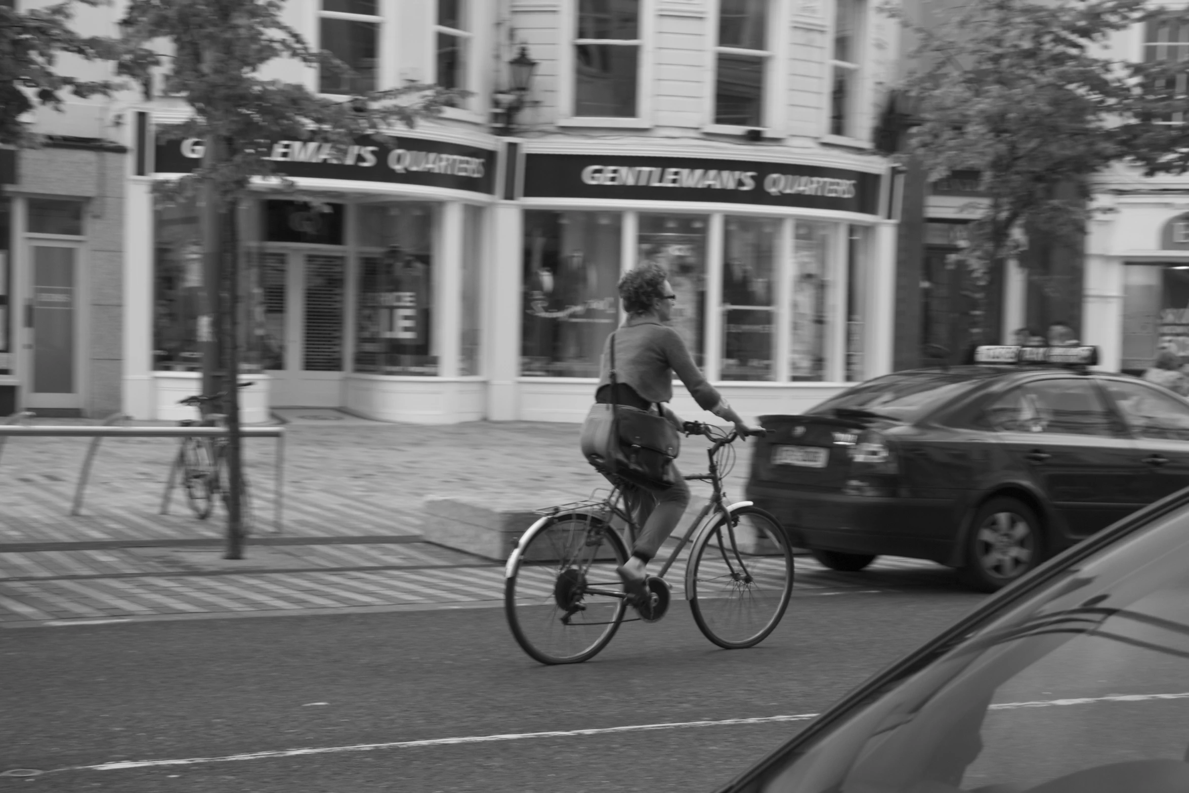 a black and white picture of a man riding a bike