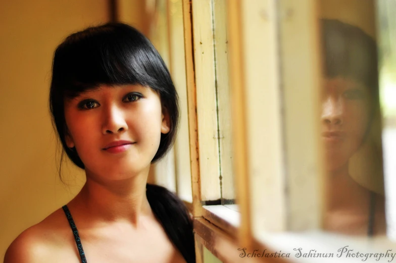 a little girl standing next to an open window