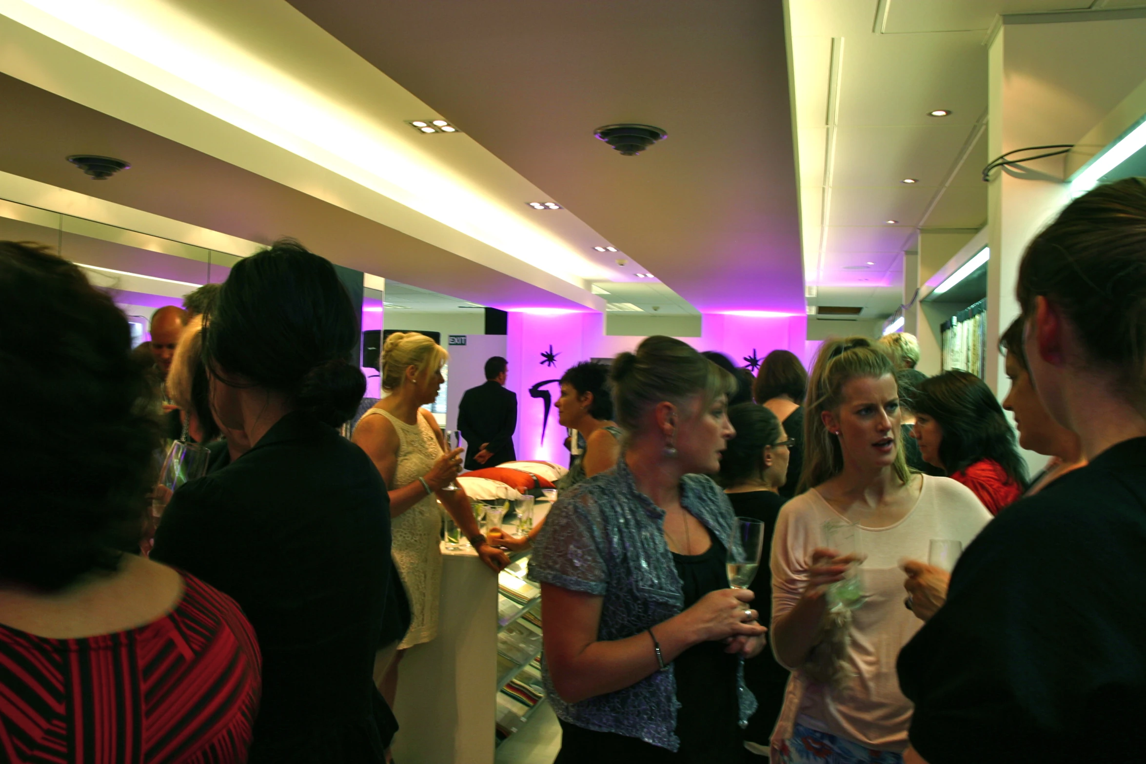 a crowd of people are standing in a hallway