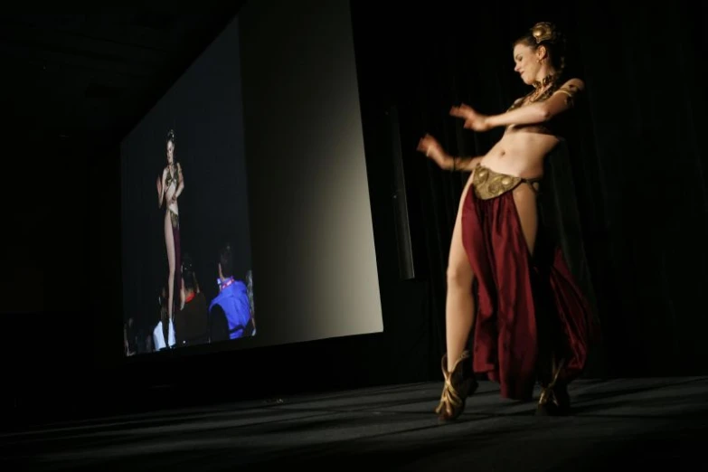 the woman in an oriental costume performs a belly dance