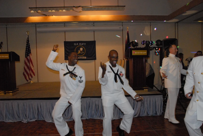 some men dancing in white suits and medals