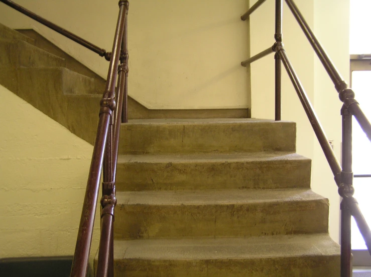 a stairway with wooden handrails at the top