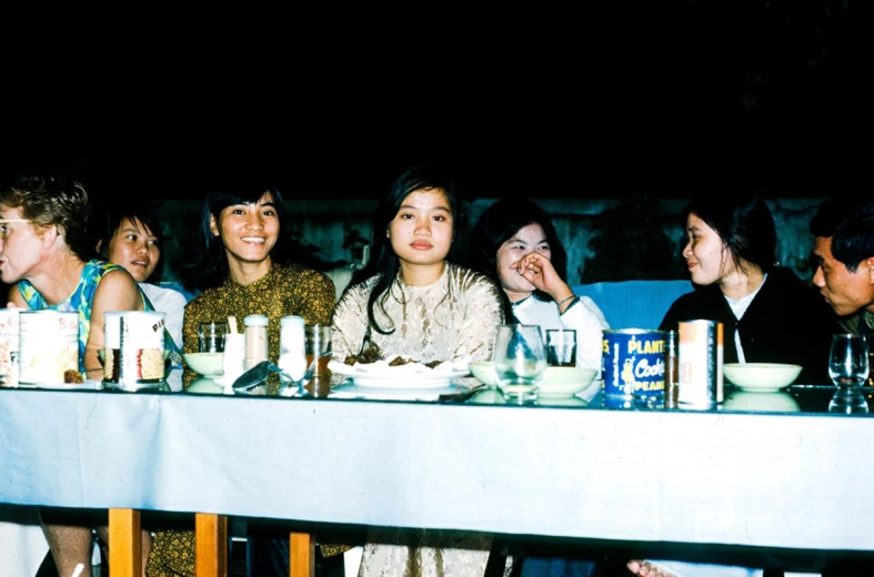 a group of people sitting at a long table