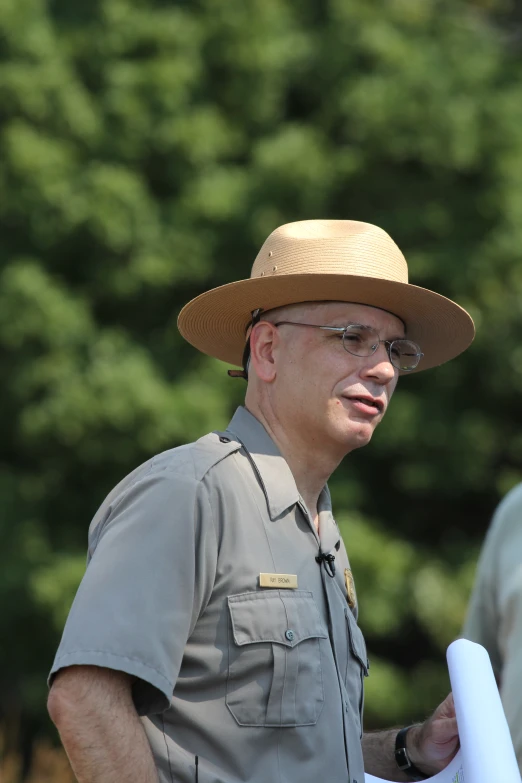 a man in a straw hat standing next to a paper